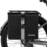 Velotric Rear Rack Pannier Bag in black with adjustable strap attached to bike rack