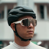 Cyclist wearing matte black Lumos Ultra Fly helmet with sunglasses.
