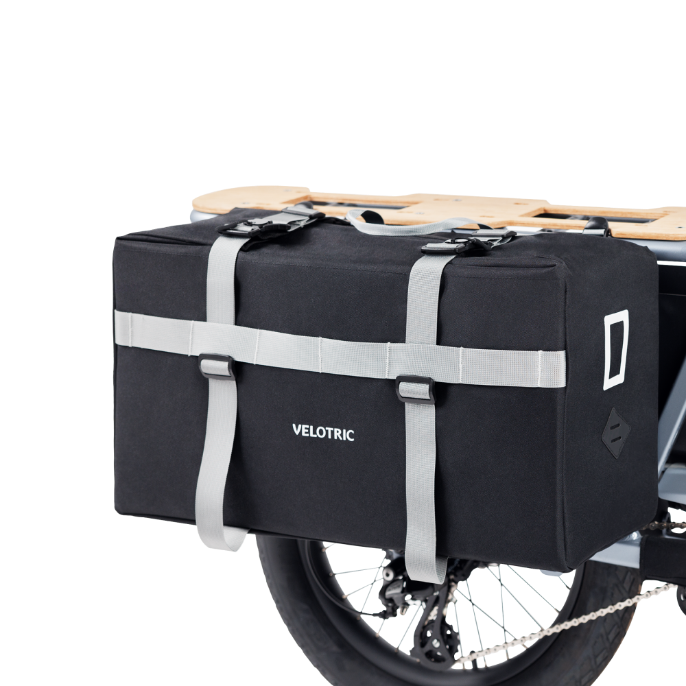 Black Velotric Packer Pannier Bag with sturdy straps attached to bike rack.