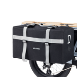 Black Velotric Packer Pannier Bag with sturdy straps attached to bike rack.