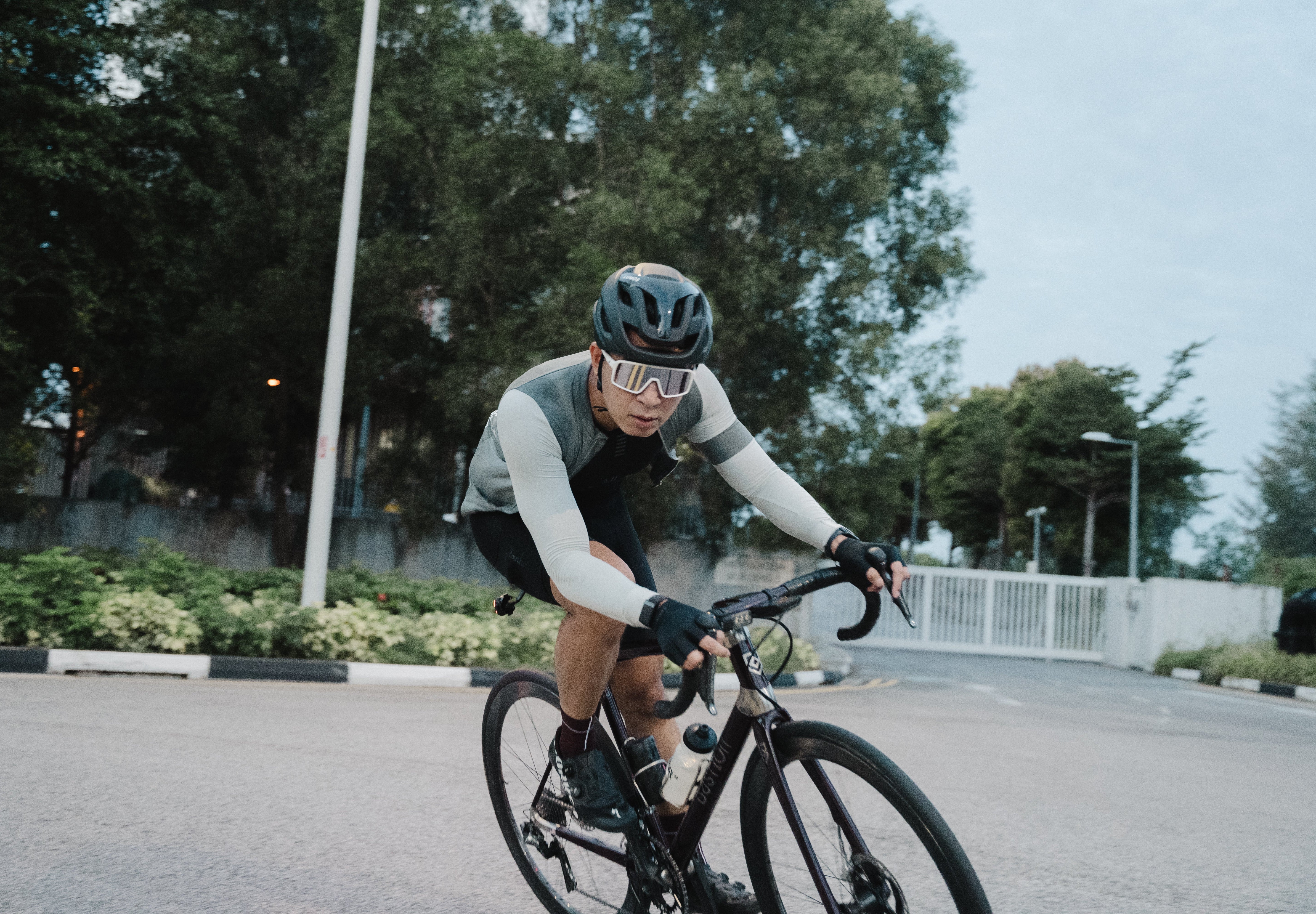 Cyclist wearing Lumos Ultra Fly Pro helmet speeding on a city road.